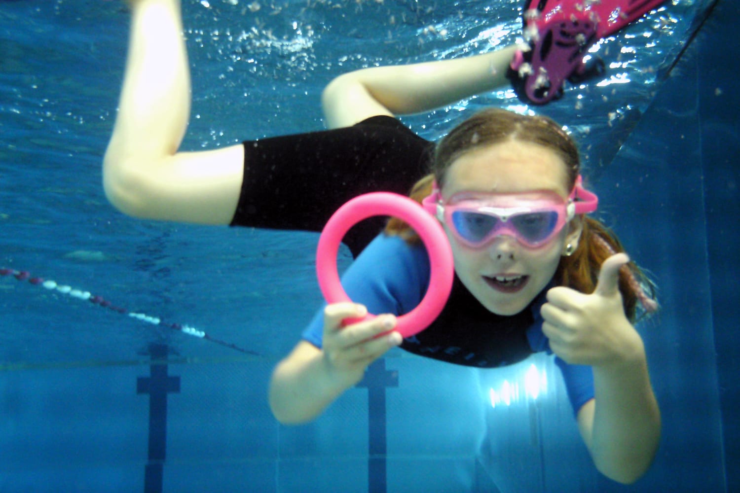 Mädchen unter Wasser mit Tauchring