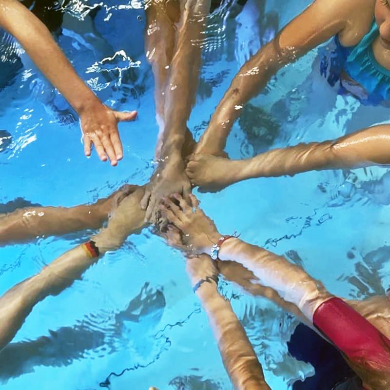 Kinder legen Hände im Wasser zusammen
