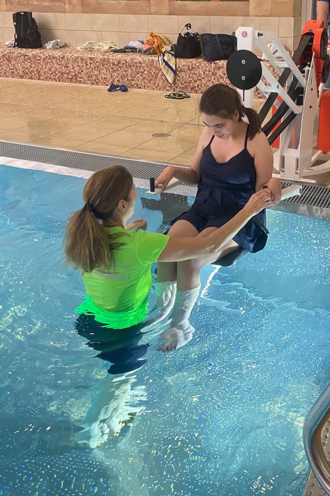 Frau wird maschinell unterstützt ins Wasser gelassen